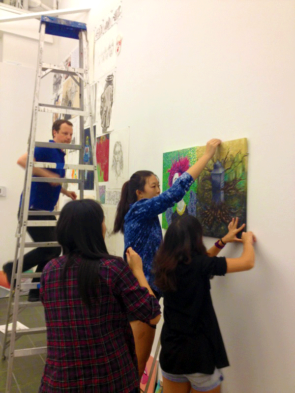 Students hanging Giffords paintings in preparation for the gallery showing.