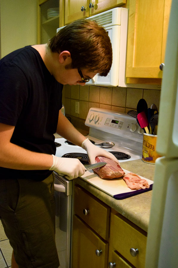 Welborn cuts off the fat before slicing the meat.