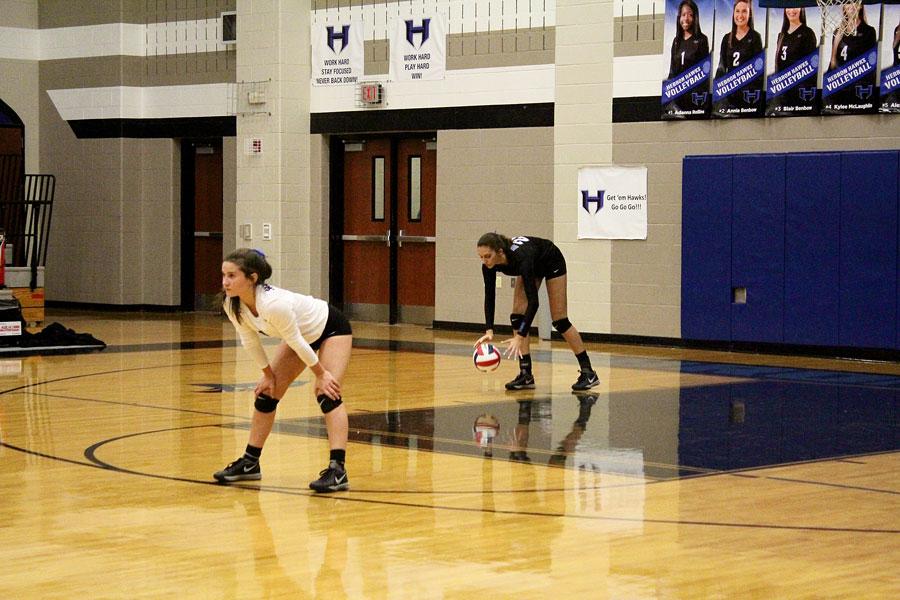 Freshman Nicole Drewnick (Right Side) goes back to serve, while libero Junior Annie Benbow prepares for defense.