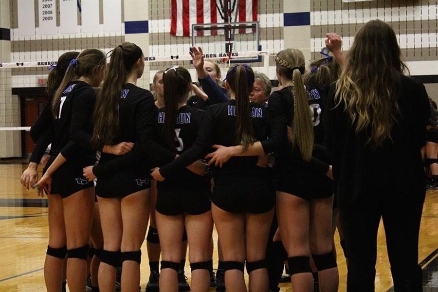 Coach Karin Keeney motivates the players as they huddle together during the timeout to talk about their strategy.