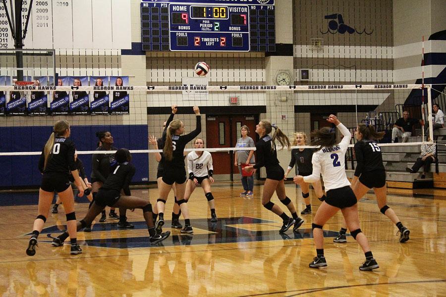 Outside Hitter, Junior Adanna Rollins and setter, Senior Kylee McLaughlin dive for a tip over middle blocker sophomore Emma Clothier.