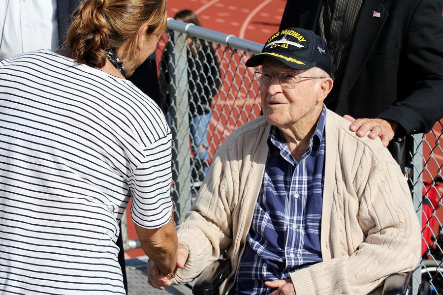 A disabled Veteran shakes hands with a teacher who attended the ceremony. He was thanked for his service to the country.