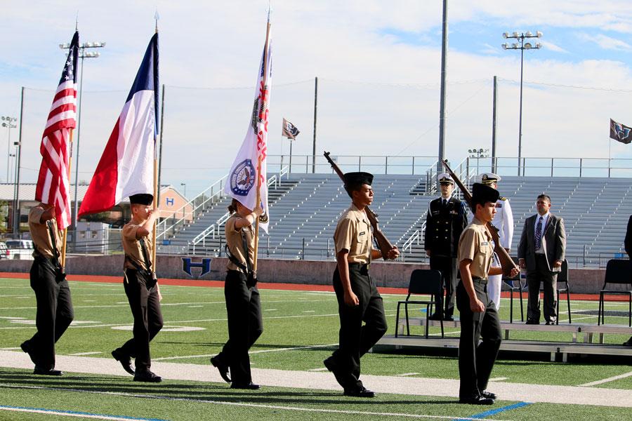 JROTC students walk onto the field with multiple flags. As they came to a halt, the national anthem began, initiating the assembly.