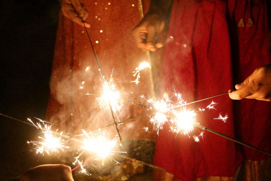 Children light sparklers together as they try to create an explosion of light.