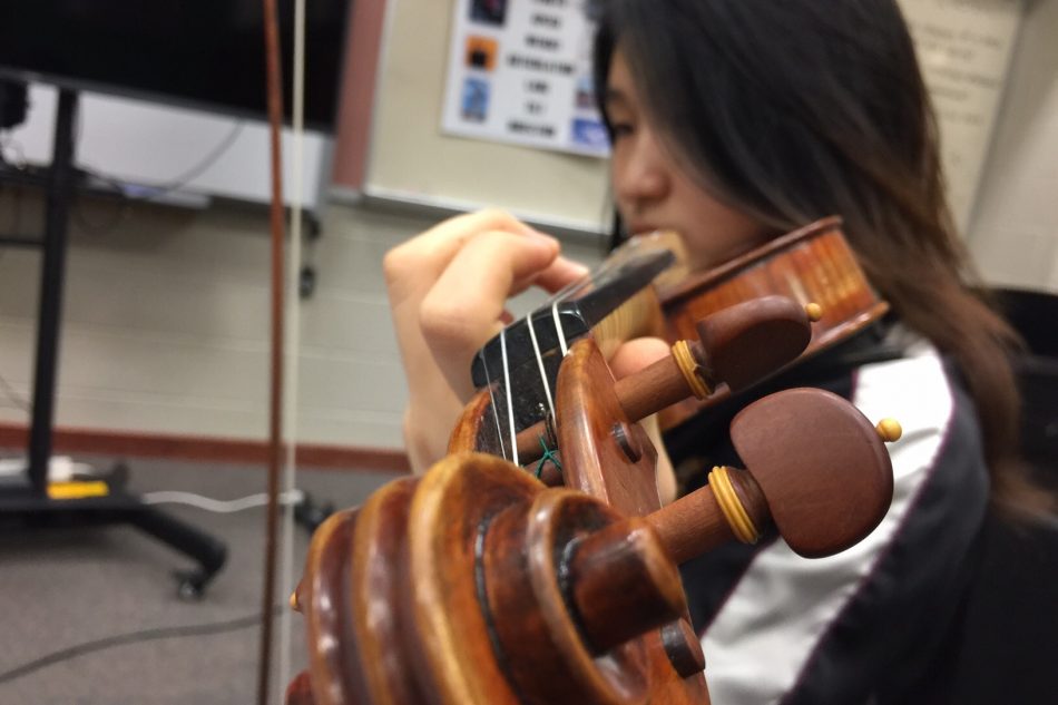 Kang practices a new piece assigned by Cautivar. Kang has been playing the violin for more than seven years and has been a part of an orchestra for more than three.