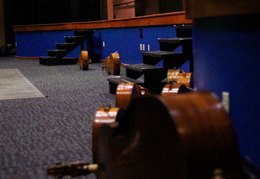 The students lay their cellos and basses down in front of the stage when not performing. 