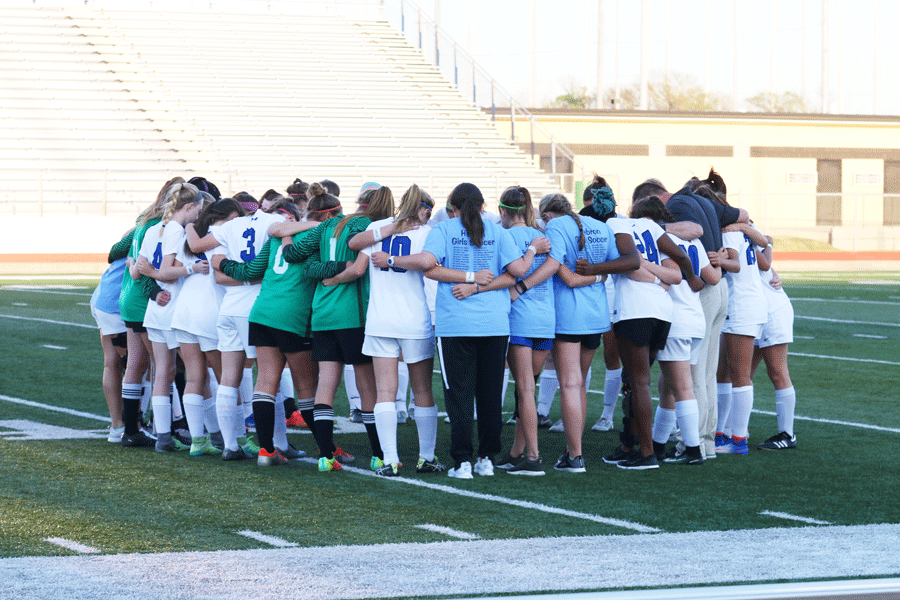 The girls soccer team huddles up before the game.