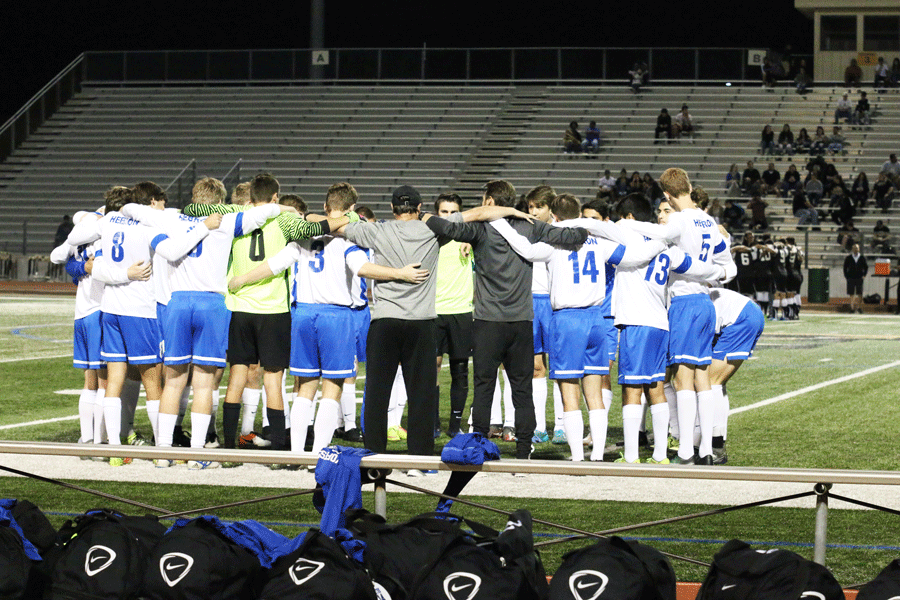 The boys soccer team huddles up before the game begins.