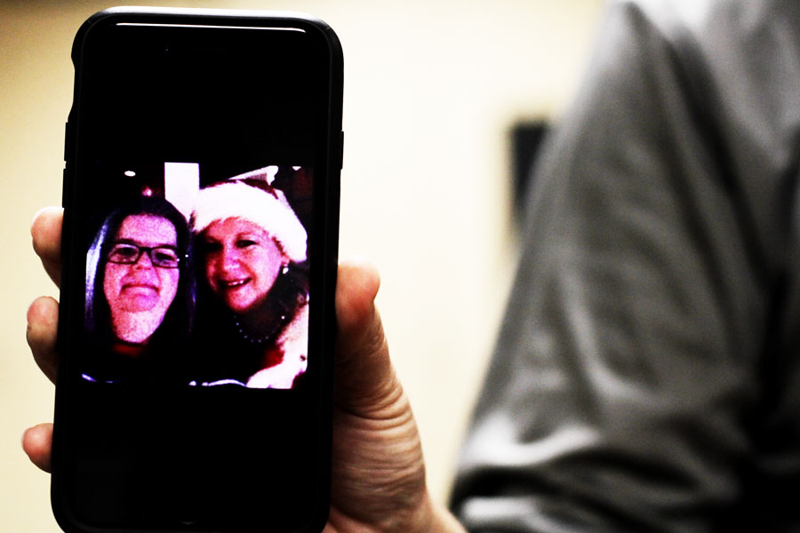 Mayo holds up a picture with her (left) and Renick (right) at a Christmas party. Every Christmas, Renick dressed up as Mrs. Claus for pictures.