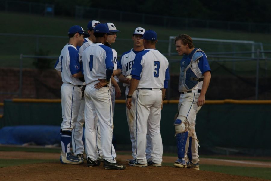 Coach Stephen Stone and players huddle to talk about their strategy. 