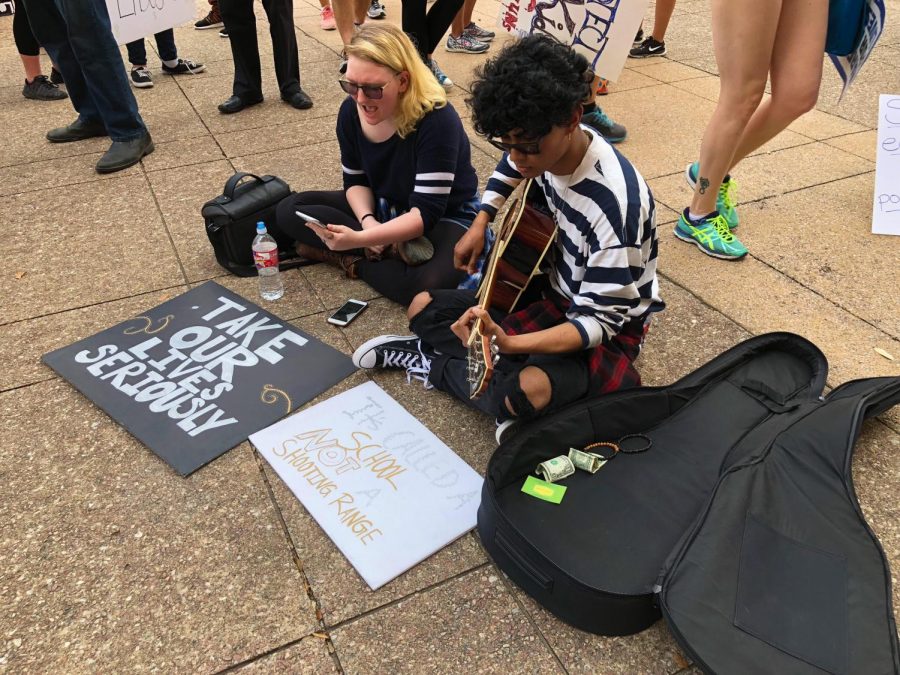 Two teen supporters sing and play guitar during the march to raise awareness of the heightening danger of guns.