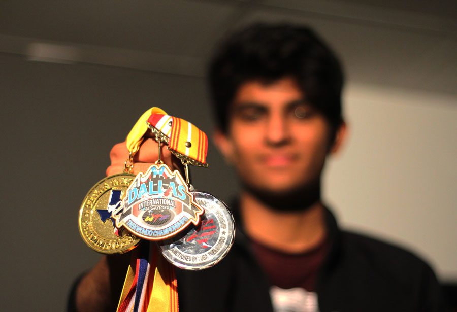 Senior Imran Abdul poses with medals he has earned throughout years of Taekwondo. Abdul was qualified as an International D-1 referee in 2015.