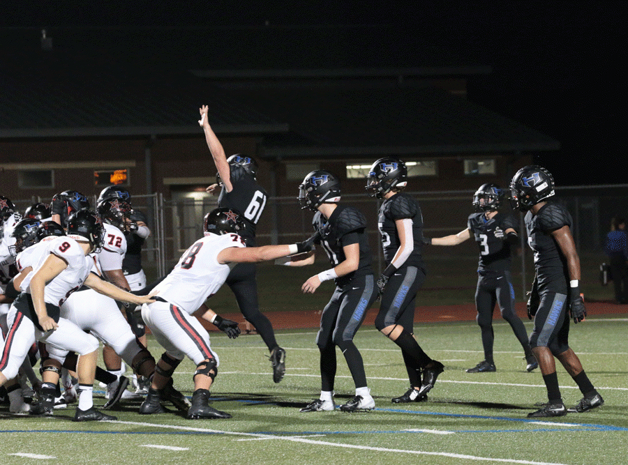 The Hebron defensive line attempts to block a PAT kick, with senior defensive end Dylan Benson leaping into the air. 