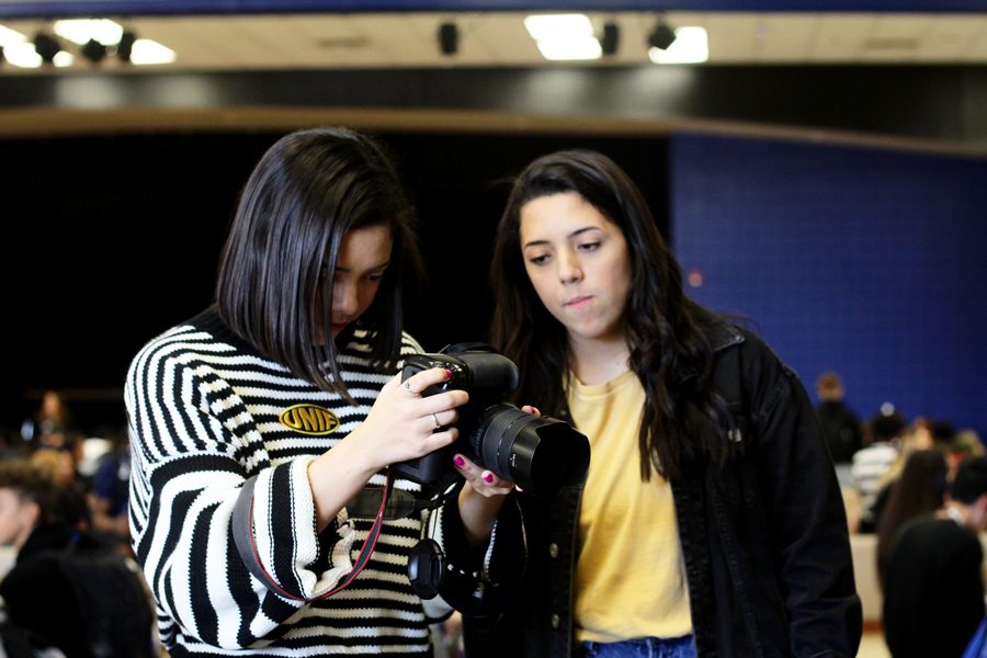 Seniors Krista Kummerl and Kayla Kummerl check the pictures they took for their Instagram account. They are looking for additional photographers to help add to the Instagram.