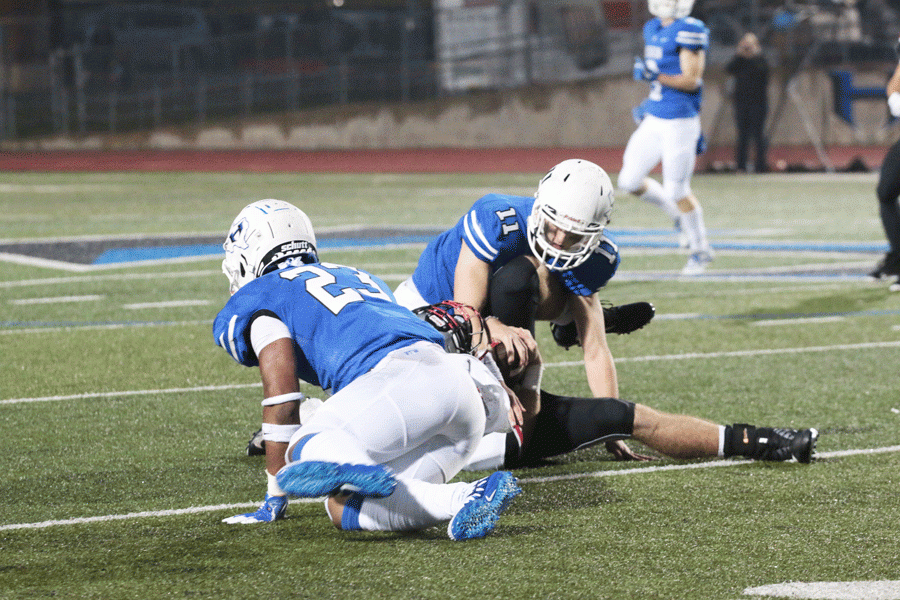 Senior linebacker Alex Day and junior Darius Snow work together to tackle a Marcus player. 
