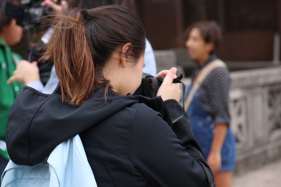 Junior Azuzena Mondragon takes a photo of a student. 