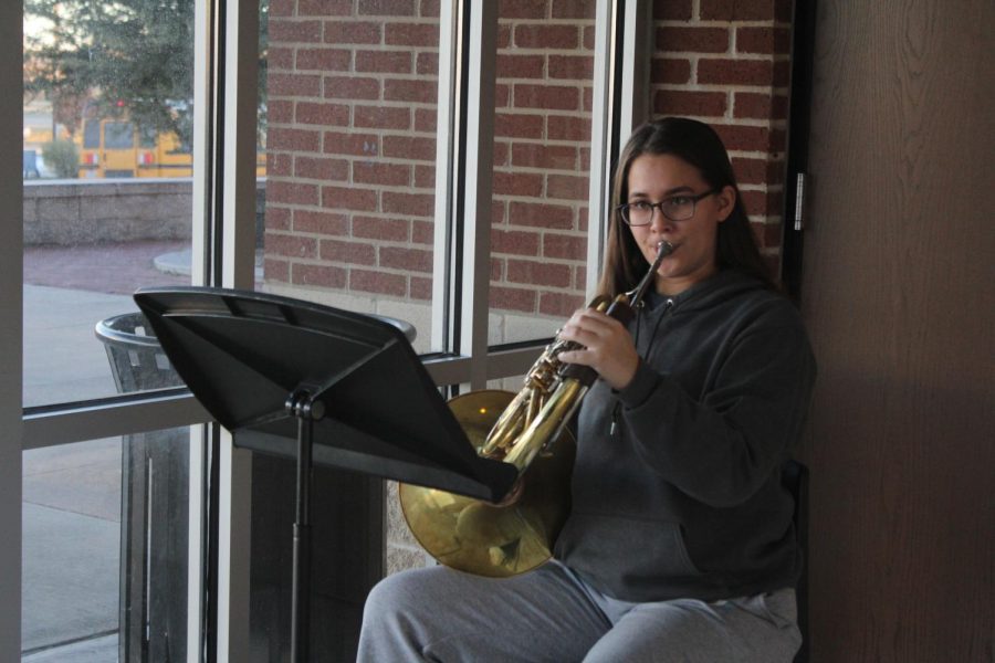 Junior Xinrae Cardozo warms up on her French horn before school. She is a three-time Area musician. 