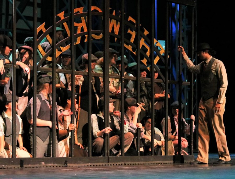 Newsies wait for the daily headline as Oscar (junior Krishna Nair) opens the gate. This rehearsal was a stop-and-go rehearsal, where the show is stopped to adjust technical elements.  