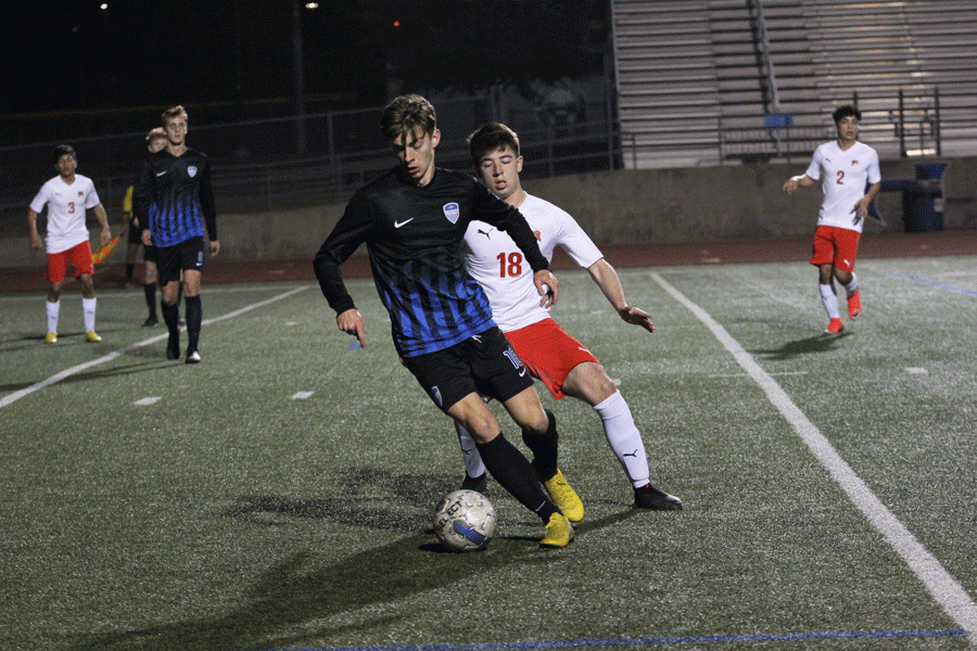 Senior Jack Prather blocks a MacArthur player from getting the ball. 