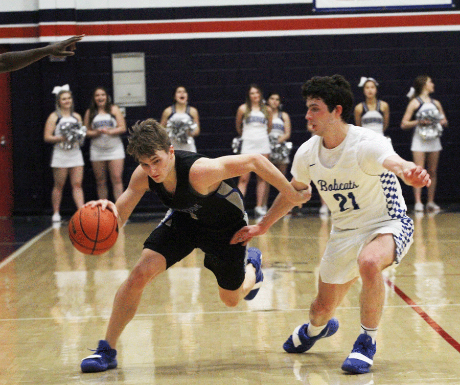 Junior point guard Logan McLaughlin dribbles the ball down the court. 