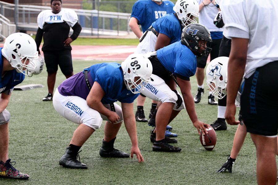 The football team lines up to snap the ball during a spring football practice after school on May 8. The teams will scrimmage each other during the spring game on Wednesday at 7 p.m..