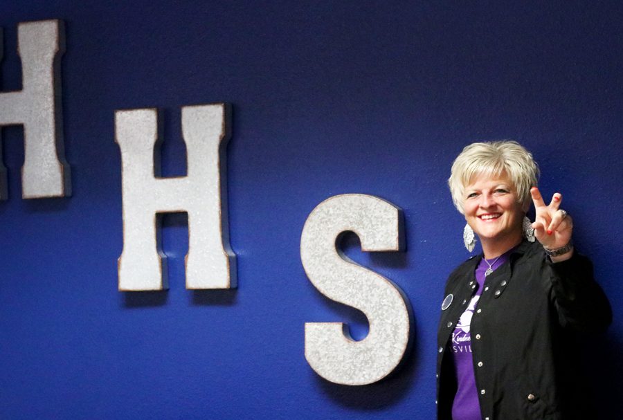 Principal Amy Boughton poses with the HHS wall in her office.  Boughton moved into her office the weekend after her appointment on June 20.  