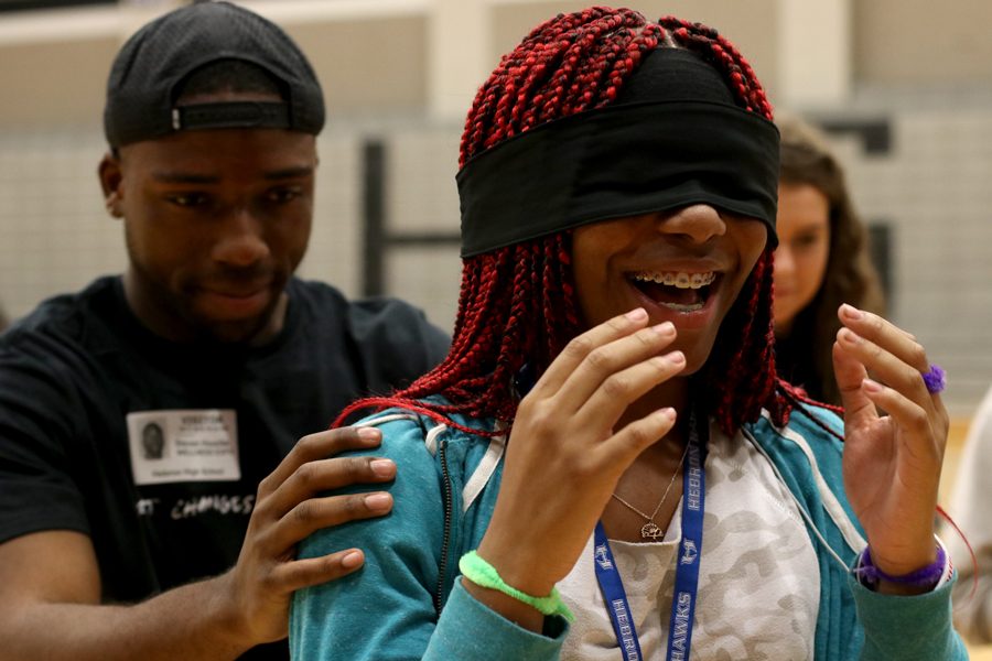 A Nike employee leads sophomore Breanna Britton, who is blindfolded, toward an obstacle course made of Nike shoe boxes. 