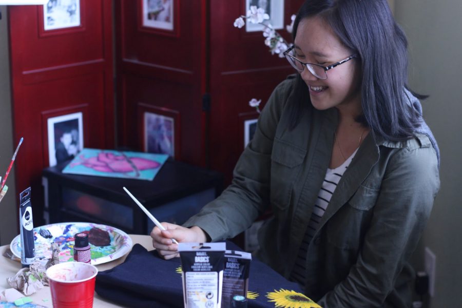 Junior Emily Nguyen paints a new article of clothing in her home on Sep 16. She posts her commissions and other works of art on her Iinstagram @dancing_manatees_inc. 
    