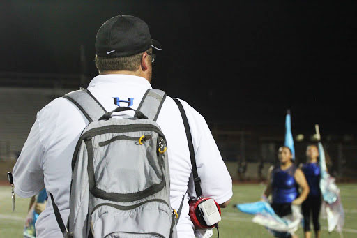 Color guard director Justin Sullivan watches the halftime show as the color guard performs along with marching band. Before every game, the whole group practices their performance as Sullivan gives directions. “They are great students, they work hard and want to get better and learn new things,” Sullivan said.