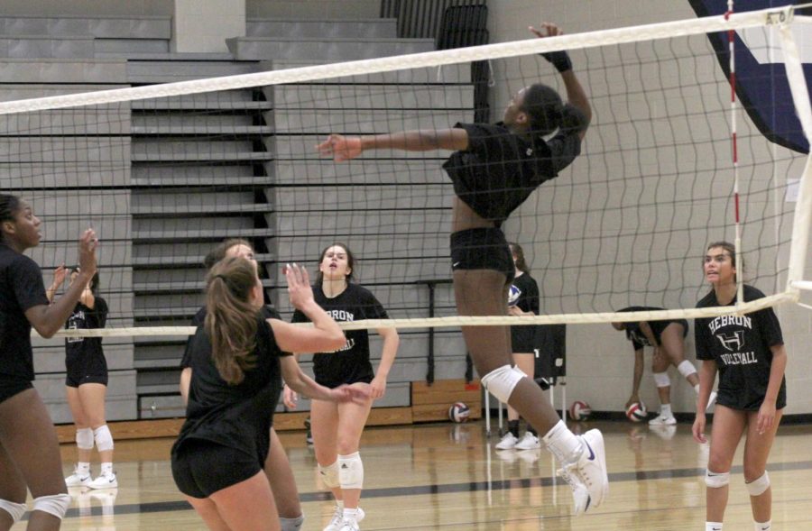 Sophomore Lia Okkamor jumps up to hit the ball at a practice before school on Sept. 26. The team practices every week depending on the day its either in the morning or after school. “My life revolves around volleyball, so it gets hard to manage my other work,” Okammor said. “I can overcome it.”
