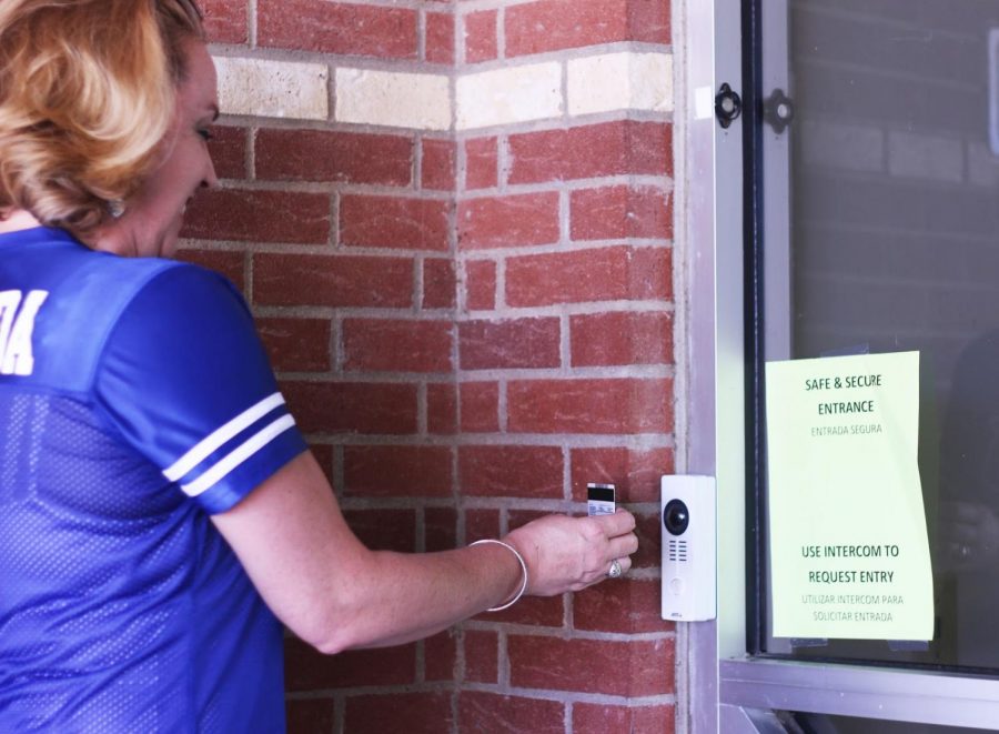 Parent Kimberly Estrada shows her ID to the video doorbell so that she can enter the school for the pep rally. Estrada has two kids that go to Hebron, and even though the whole process of getting into the school is tedious, she feels assured that they are safe inside the building. “It makes me feel safe as a parent to know that my kids are in a place where security is held in high regard,” said Estrada.