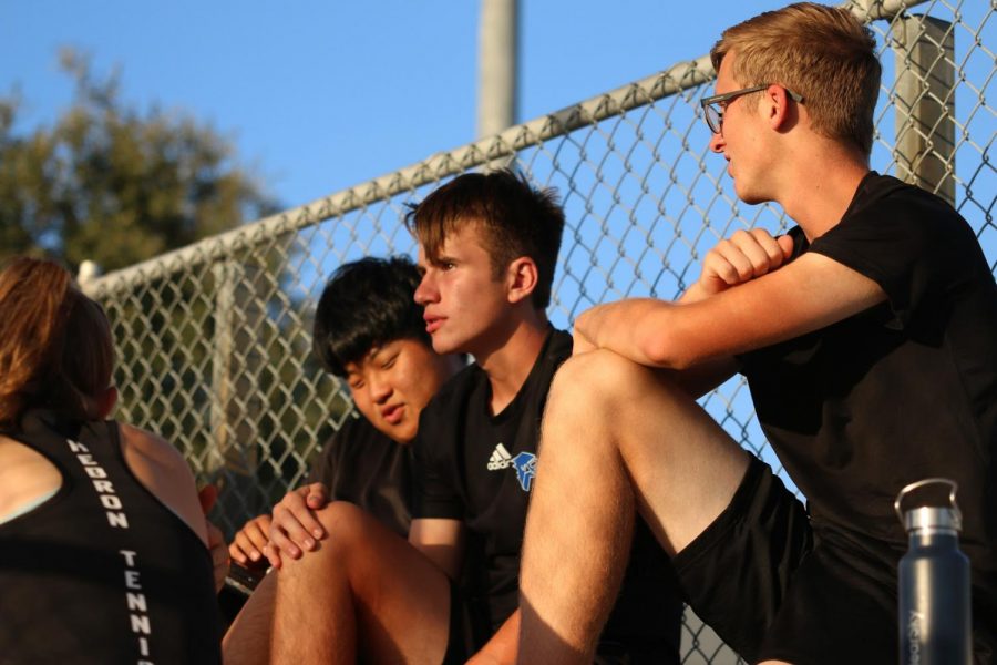 After completing their matches, junior Robert Hererra and senior Sam Song sit in the bleachers to watch a teammate play. For singles matches, they play two sets and a tiebreaker, while in doubles they play a pro set of eight games.

