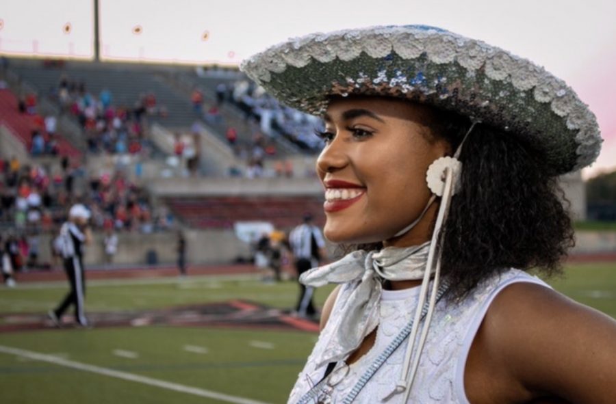 Senior Mariah McCardell smiles to the crowd during a football game at Coppell on Oct. 4. McCardell is the first African-American captain for Silver Wings. 