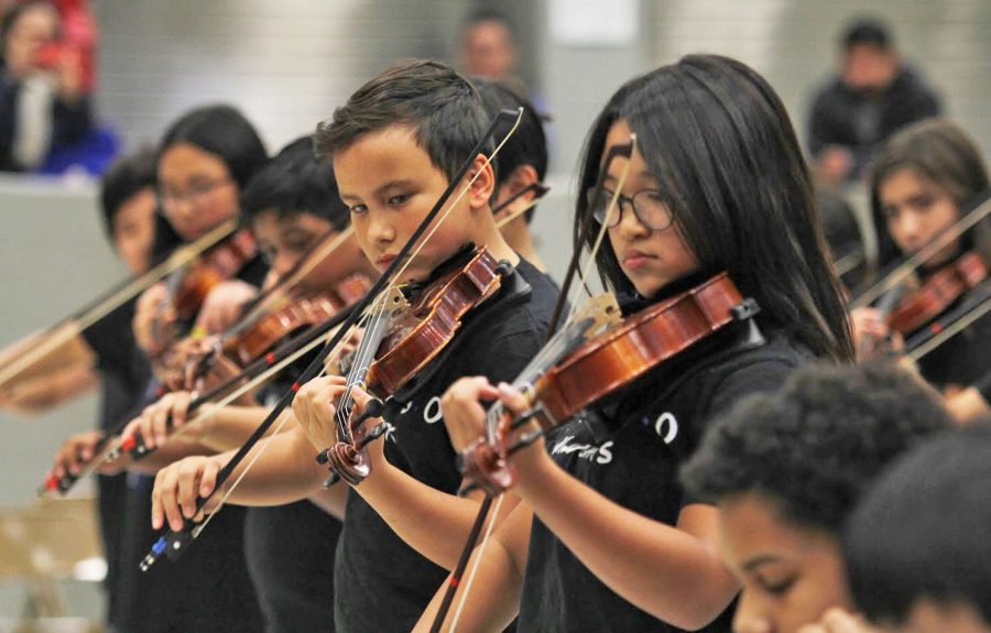 Creek+Valley+middle+schoolers+in+the+beginner+orchestra+play+a+Christmas+song+as+a+part+of+their+winter+concert+performance.+They+had+played+along+with+the+7th+and+8th+graders+in+the+higher+orchestra+while+Michelle+Kong%2C+the+director+at+Creek+Valley+and+Arbor+Creek%2C+directed+both+of+the+orchestra+groups.