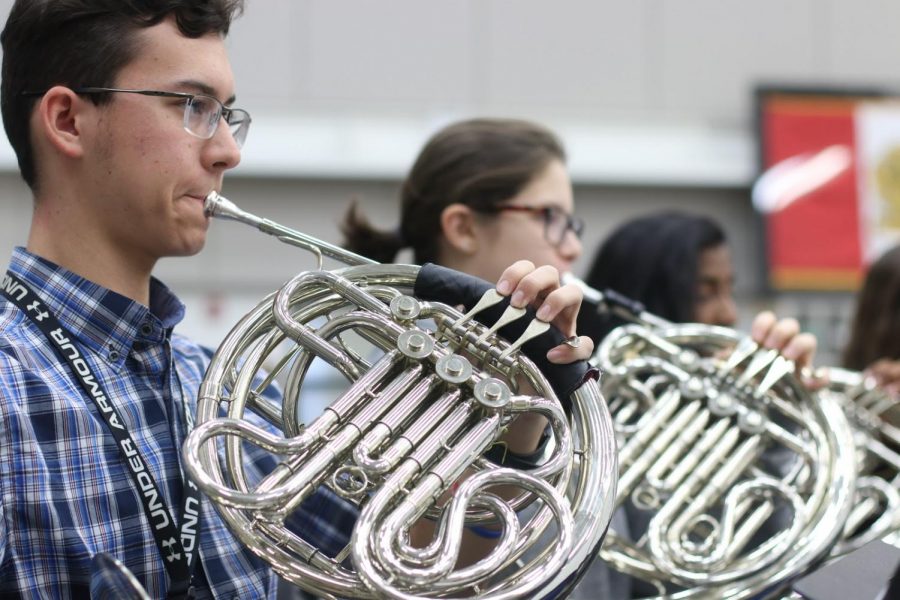 Junior David Howe plays fundamentals during a concert band rehearsal on Dec.10. Before working on music, every band class practices breathing, buzzing on brass mouthpieces and playing fundamental exercises to develop the sound of the ensemble. 