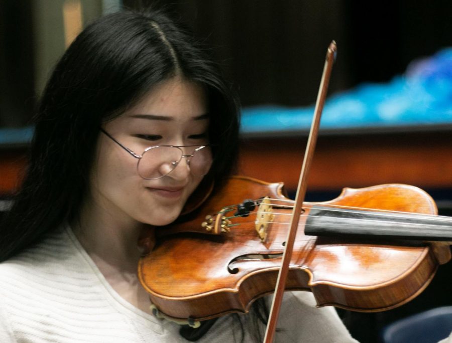 Senior Grace Kang practices her part for the upcoming musical. Although she plans to study visual art in college, she hopes to continue playing violin in future musical performances. “If I have the opportunity to get paid to play in different musical performances, that would be awesome,” Kang said. “I would definitely sign up for that.” 