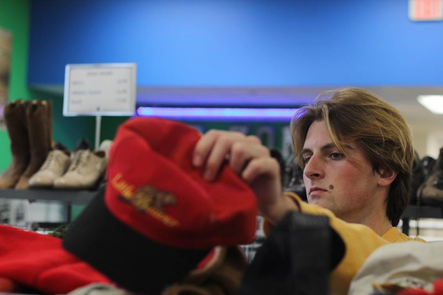 Junior Ethan Pettengill looks through a selection of hats at Goodwill. Pettengill has a clothing line named “personols,” which he creates by refurbishing vintage clothing.