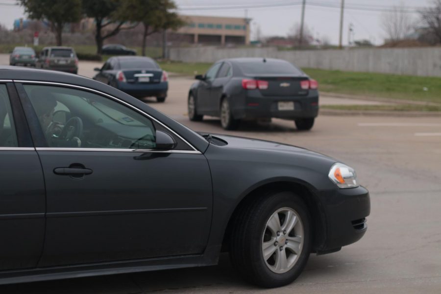 Student merging into the main lane in the upper parking lot to leave school. Usually when the traffic is worse, these merging lanes create big issues.