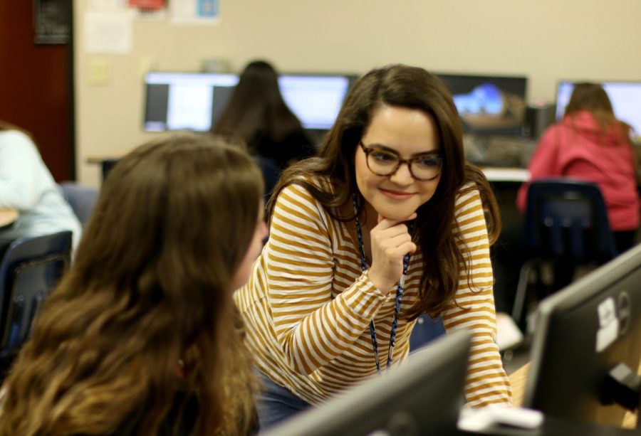 Yearbook adviser Madalyn Cooper helps a student with their design template. It is Cooper’s first time teaching at a school with a four period class schedule.	“I am used to teaching eight periods a day, so having the for period block period was new to me,” Cooper said. “So everything was strange at first, and it took a lot of getting used to.”
