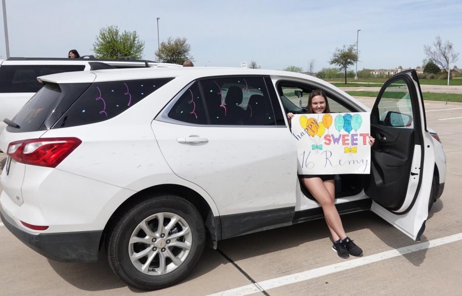 Sophomore Audri Fleming poses in her decked-out car along with a poster she made. Fleming and some of Wiebers closest friends were invited to participate in this festive caravan.