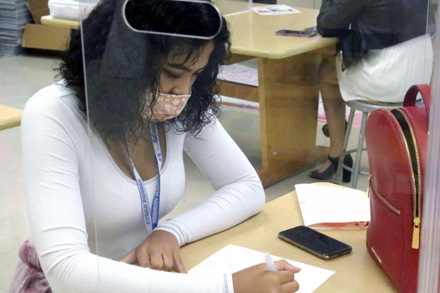 Senior Cinta Isom works on her art behind a plexiglass desk shield. She is on the Virtual Plus learning pathway and only attends school for second period.