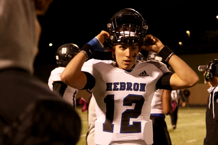 Senior Weston Conaway, with his right thumb wrapped, takes off his helmet on the sidelines, during a game against Plano West on Oct. 23. After a game-time decision on whether or not Conaway would play, Conaway was able to play one drive in this game, but has yet to play a whole game. 