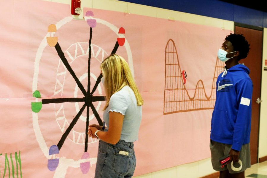 Student council members seniors Dexter Mitchell and Sydney Stafford work to finish setting up decorations for homecoming. Student council is in charge of planning and decorating the school for important events.
