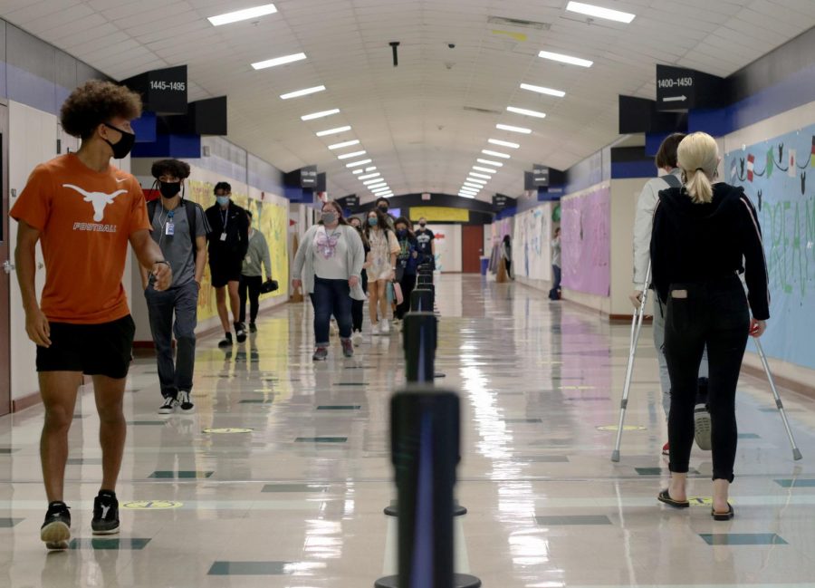 Students walk on either side of the hallway to ensure less face to face contact with each other. The Hebron Administration put the one-way walking lanes in the hallways to prevent the spread of COVID-19 at the beginning of the in-school year