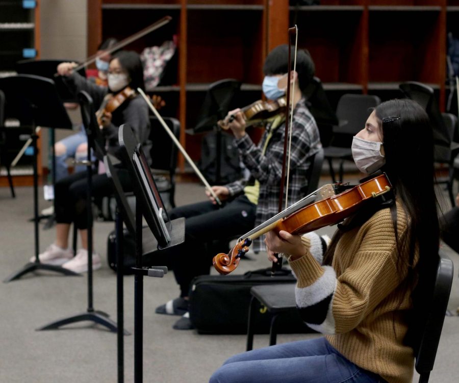 Senior Vaneeza Moloo rehearses during her third period orchestra class. Students are spaced apart and wearing masks while they practice.