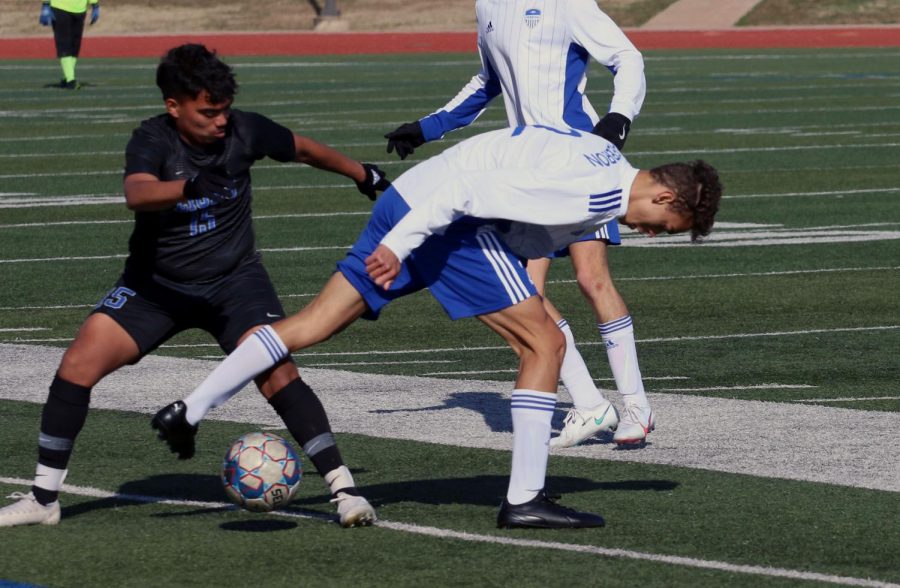 Senior Cayden Casburn weaves the ball through the legs of an opponent following a throw in. This is Casburn’s second year starting as a centre back on varsity.