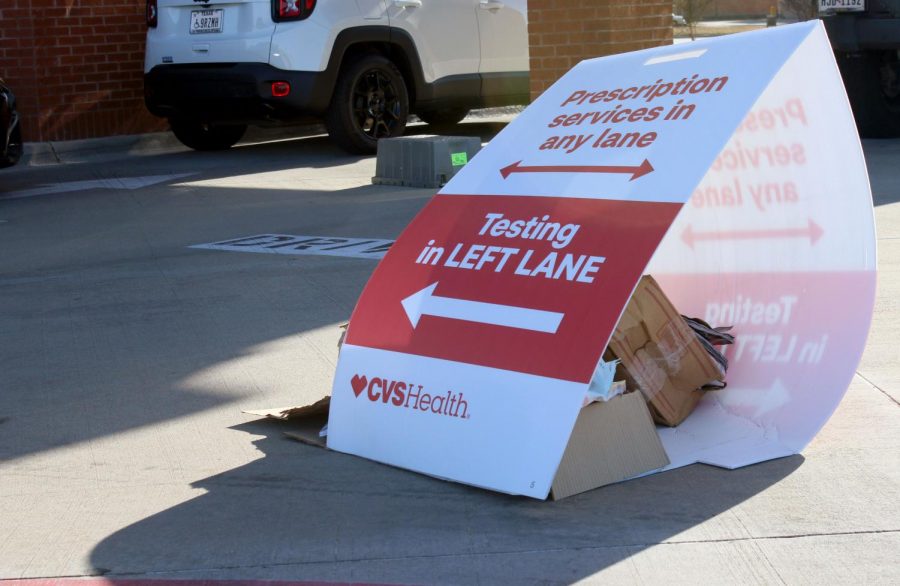 A sign is weighted down next to the CVS drive-thru, dividing the lanes. COVID-19 testing is offered at CVS locations; scheduling an appointment is required prior to getting tested. 