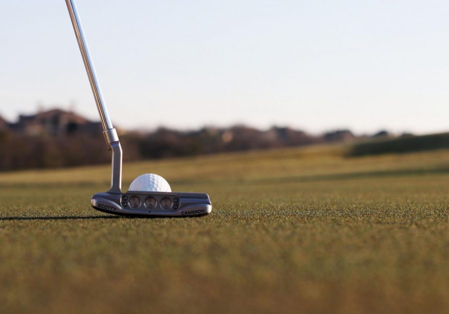 Senior Colby Beaman lines his putter up to the ball. Beaman has been on the golf team for four years.