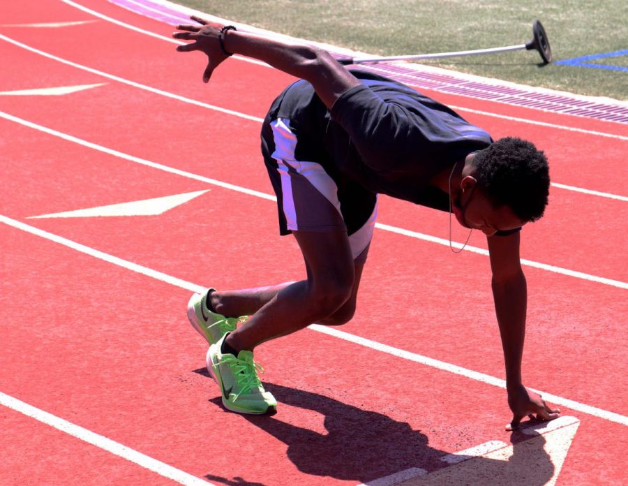 Senior Perry Aubrey gets in his starting position in preparation for the practice
100-meter run. The team practices every day during fourth period.