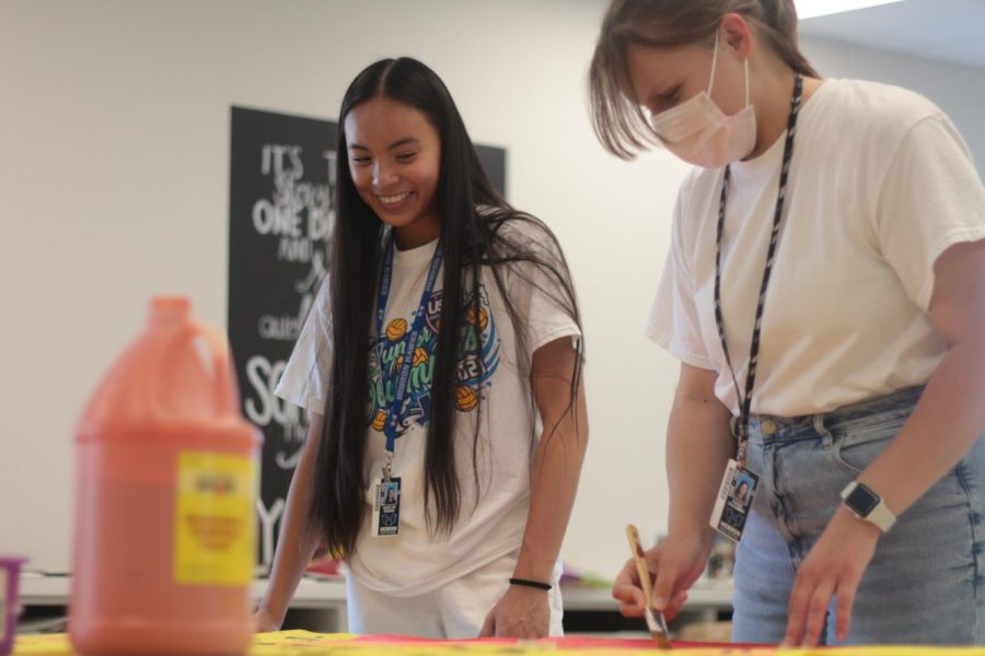 Student Council senior officer Kaitlyn Hoang and President Paige Zagumny paint a poster to promote Senior Sunrise during their third period student council class. Zagumny and the other officers spend their class period organizing, preparing and advertising school events.